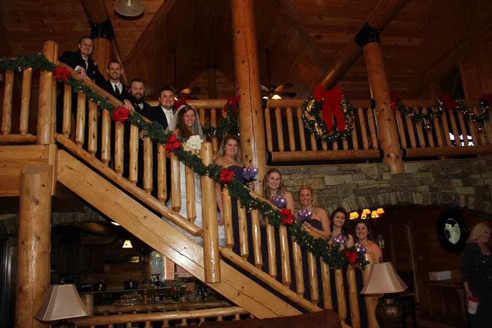 Wedding party posing on holiday decorated log staircase at Moose Hollow Lodge in Pigeon Forge