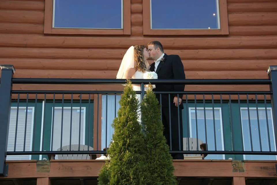 Wedding couple kissing on a rustic cabin balcony near Dollywood at Moose Hollow Lodge in Pigeon Forge