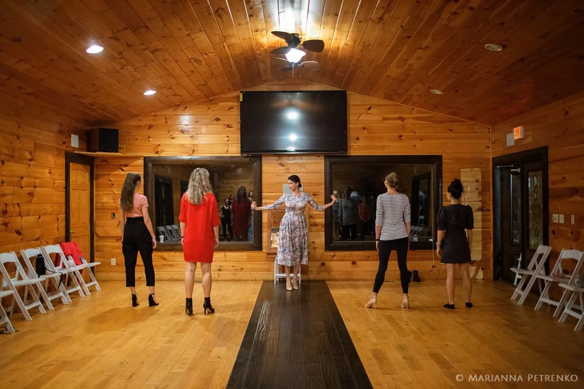 Spacious wood-paneled event room with mirrors and white chairs at Moose Hollow Lodge in Pigeon Forge