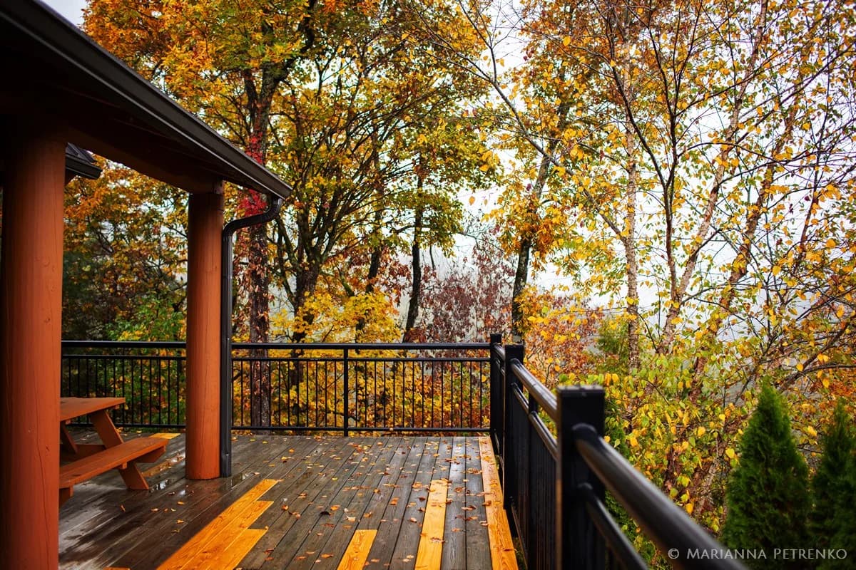 Wooden deck with autumn foliage and picnic table near the Great Smoky Mountains at Moose Hollow Lodge in Pigeon Forge