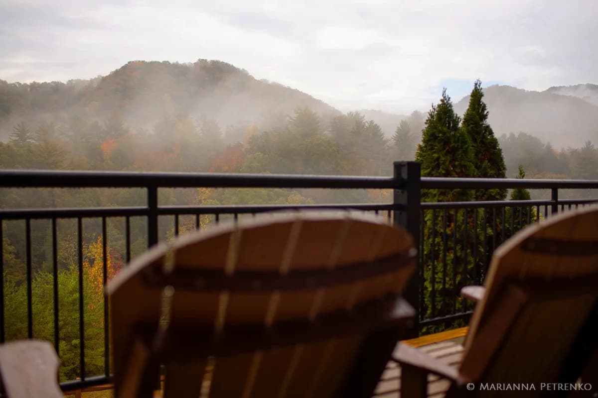 Wooden deck chairs overlooking misty Smoky Mountains views at Moose Hollow Lodge in Pigeon Forge near Dollywood