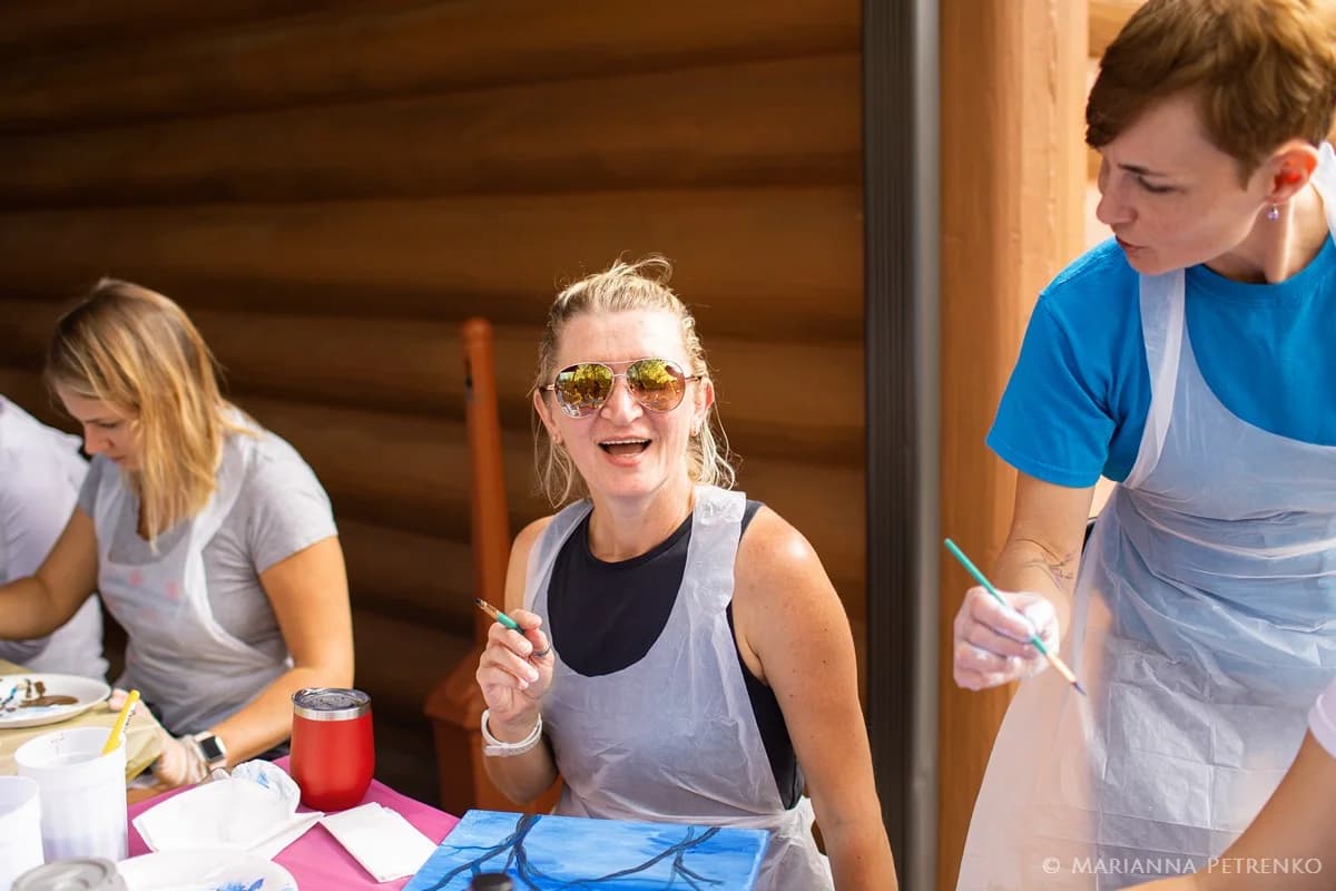 Wedding group painting activity on a rustic deck at Moose Hollow Lodge in Pigeon Forge near the Smoky Mountains