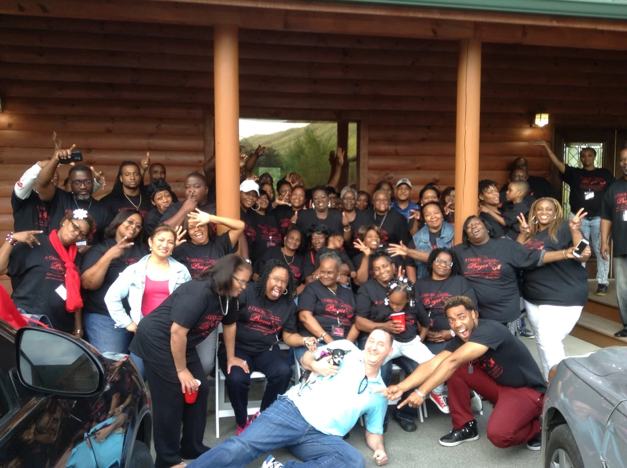 Large retreat group posing on a log cabin porch near Dollywood at Moose Hollow Lodge in Pigeon Forge