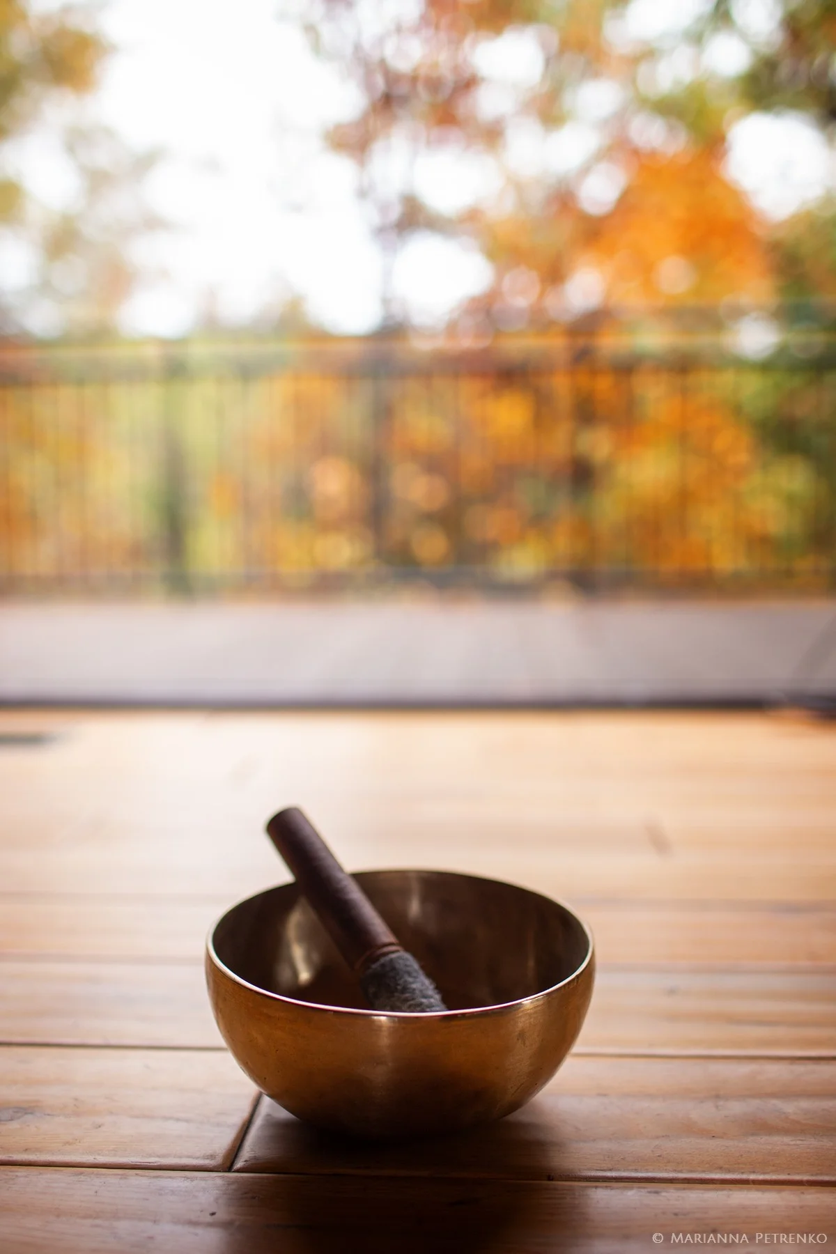 Singing bowl on wood floor with autumn forest views at Moose Hollow Lodge in Pigeon Forge