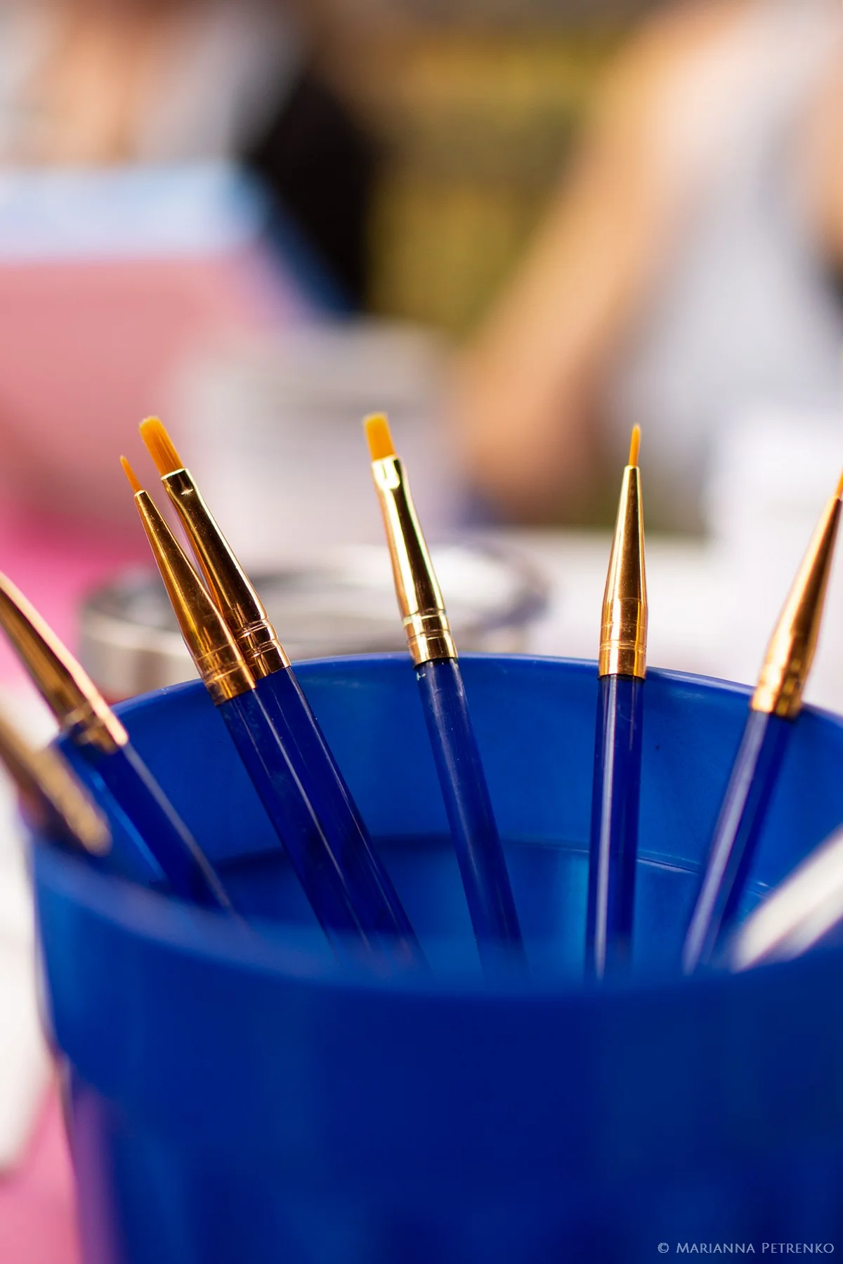 Assorted paintbrushes in a blue cup for wedding activities at Moose Hollow Lodge in Pigeon Forge