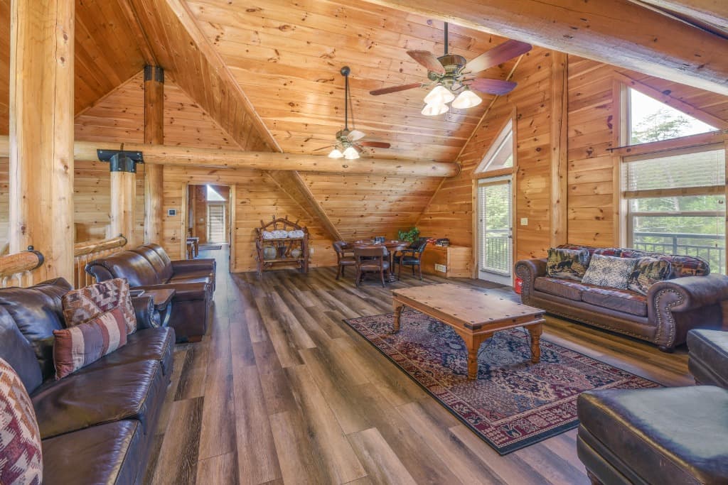 Rustic loft with leather sofas, vaulted ceilings, and log beams at Moose Hollow Lodge in Sevierville