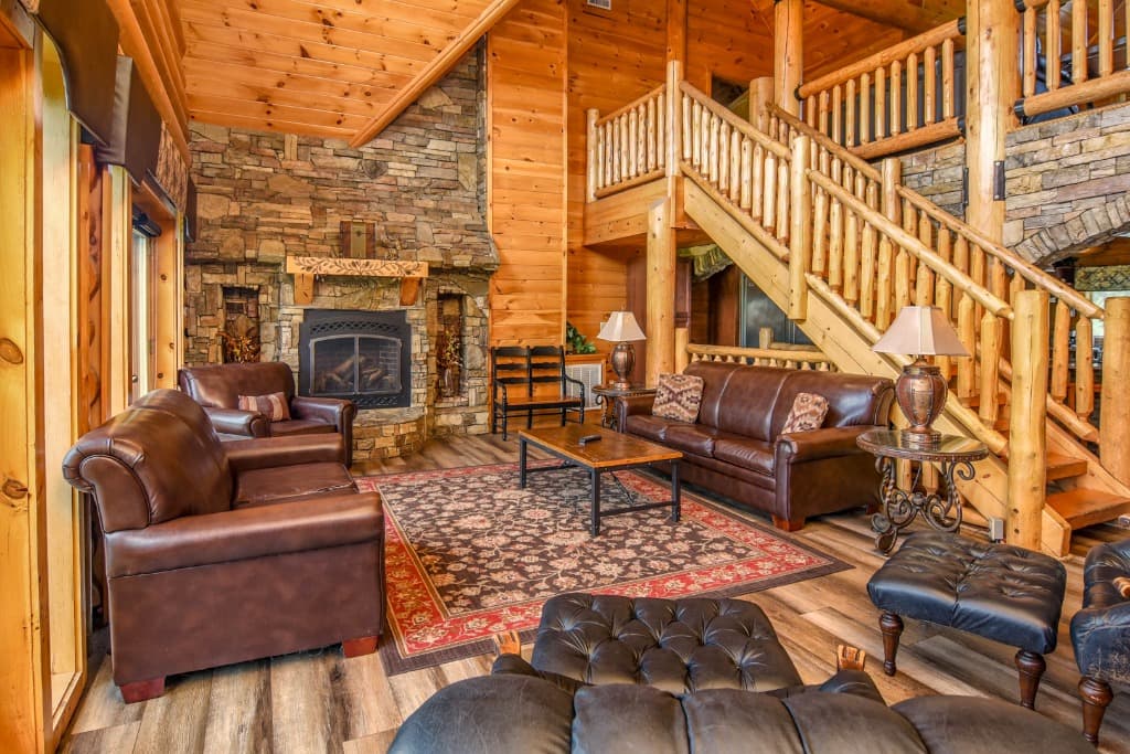 Rustic living room with leather sofas and stone fireplace at Moose Hollow Lodge in Sevierville