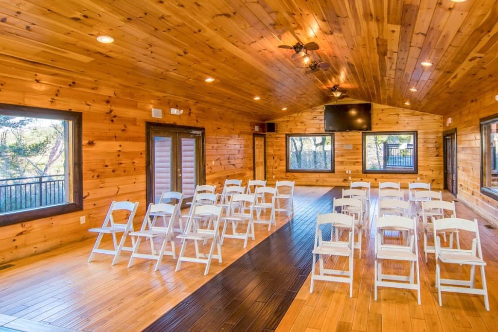 Wood-paneled chapel with white ceremony chairs and forest views at Moose Hollow Lodge in Sevierville.