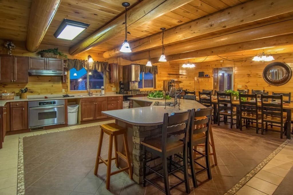 Spacious log cabin kitchen with island seating and dining area at Moose Hollow Lodge in Sevierville