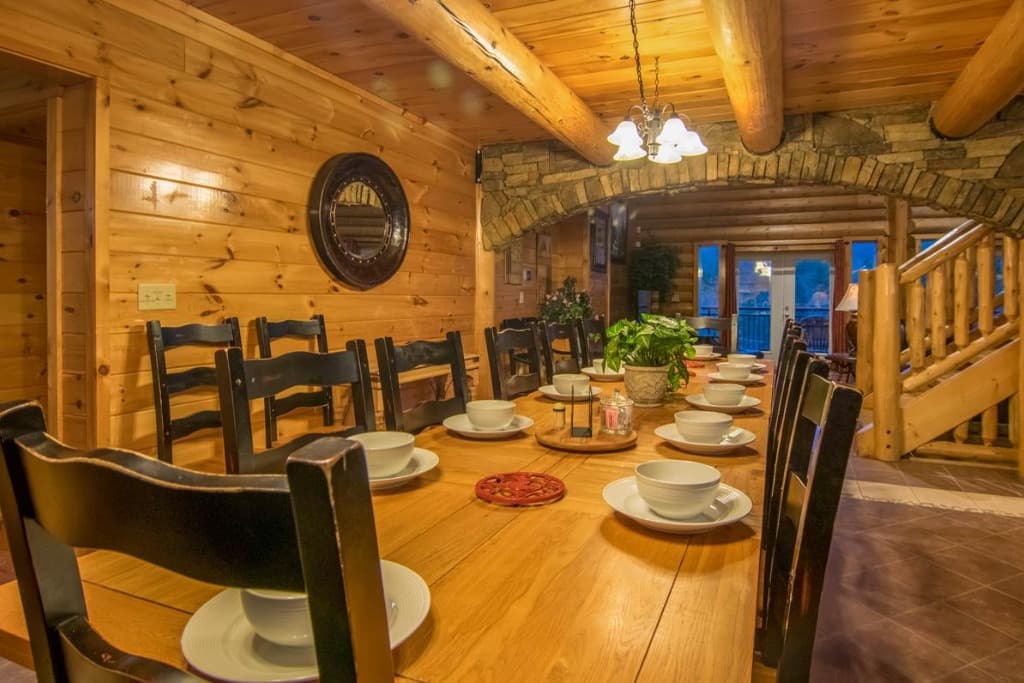 Long wooden dining table and rustic stone arch in the dining room at Moose Hollow Lodge in Sevierville
