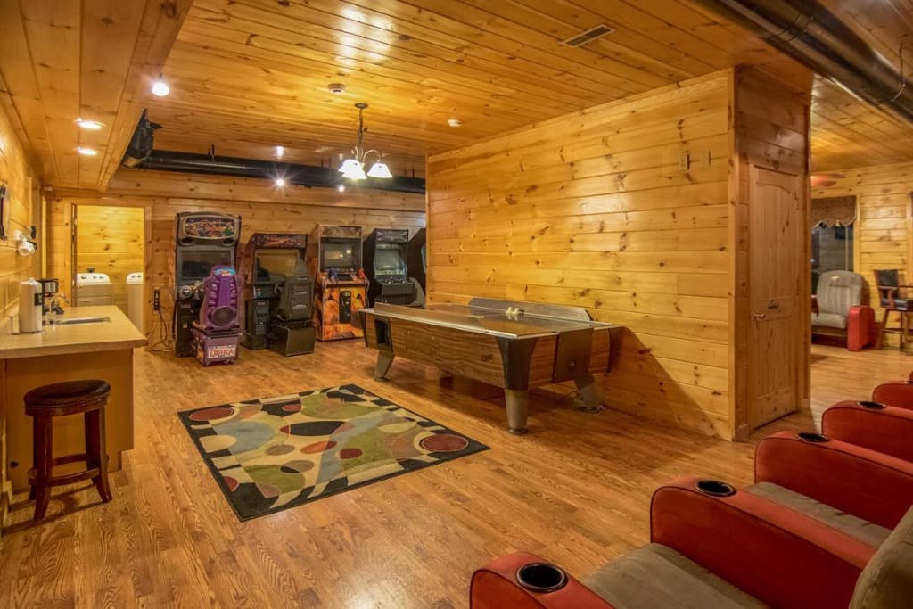 Spacious game room with arcade machines, air hockey, and theater seating at Moose Hollow Lodge in Sevierville