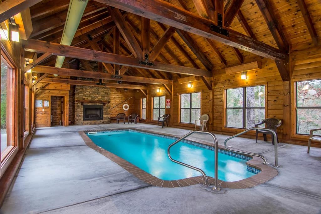 Indoor pool with stone fireplace and vaulted wood ceiling at Moose Hollow Lodge in Sevierville near Smoky Mountains